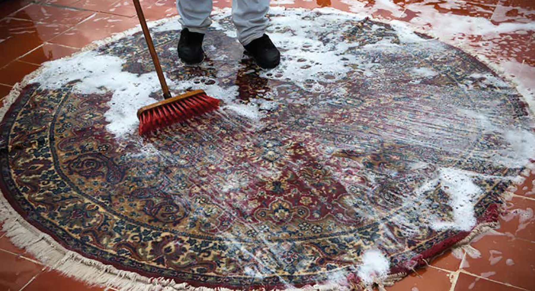 Brossage d’un tapis rond à l’eau savonneuse