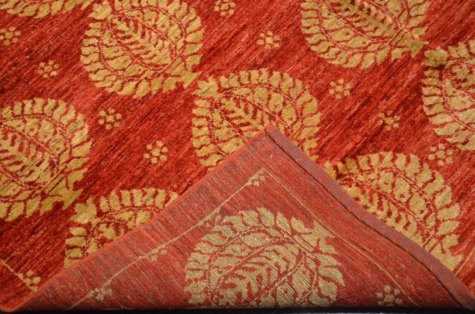 Coin d’un tapis d’Orient rouge et or après son passage à l’atelier d’Athis-Mons